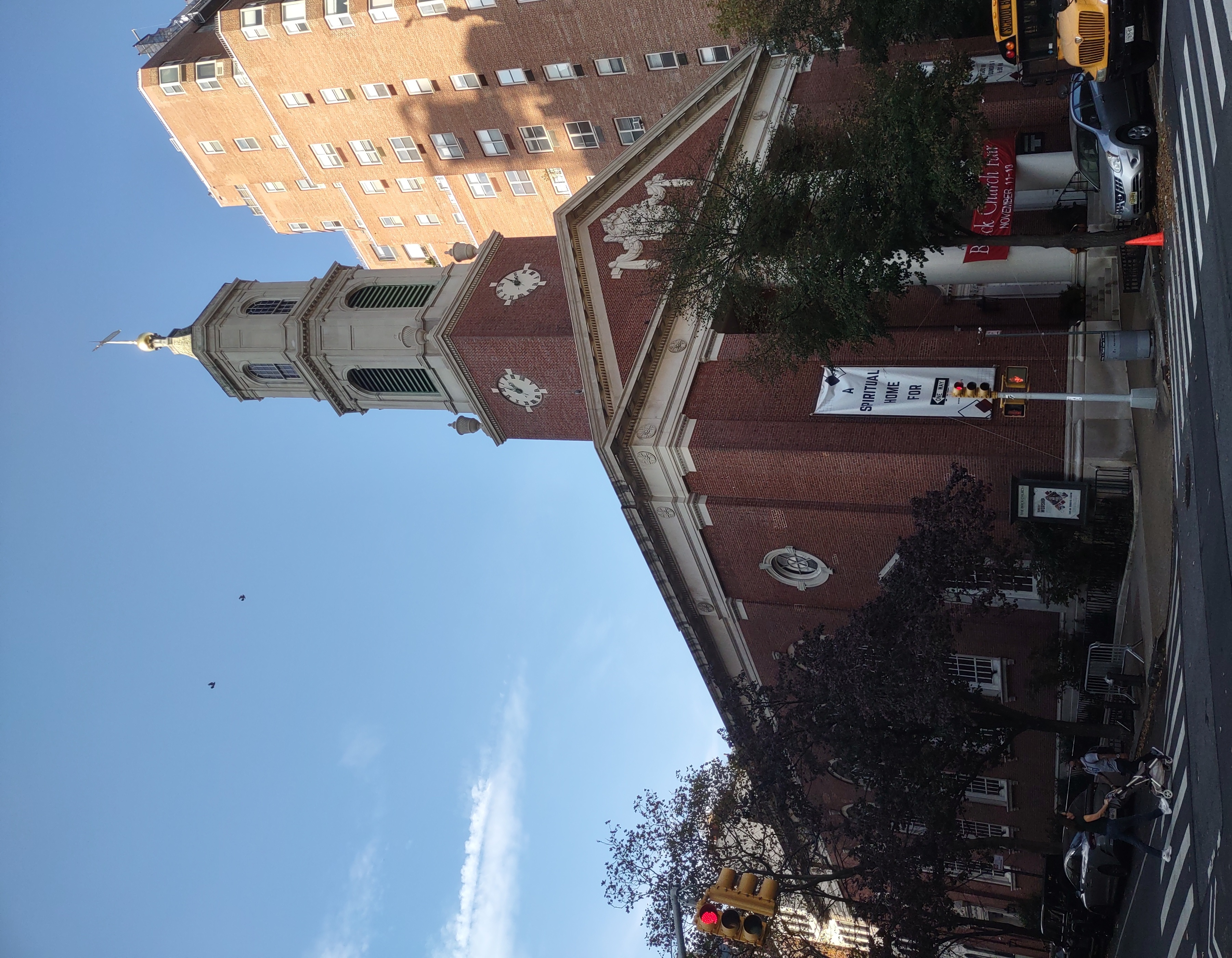 Brick Presbyterian Church from the street, with a brick clock tower, pale stepped belfry and short finial
